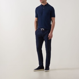 Model wearing Eleventy Iconic Polo Shirt in navy, styled with matching navy drawstring trousers and dark suede shoes.