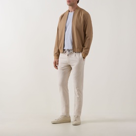 Model wearing Eleventy Girocollo Solid T-Shirt in grey, styled with a camel bomber jacket, cream trousers, and white trainers.