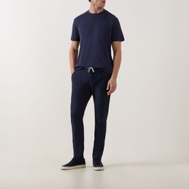 Model wearing Eleventy navy modal cotton T-shirt, styled with matching navy drawstring trousers and dark suede trainers.