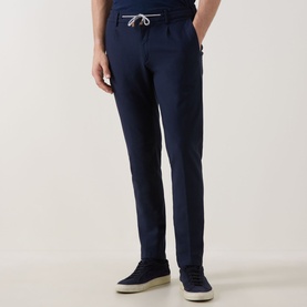 Model wearing Eleventy navy trousers with white drawstring waist, styled with navy suede trainers.
