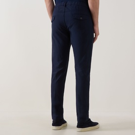 Model wearing Eleventy navy trousers, rear view, slim fit with side pockets, styled with cream canvas shoes