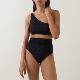 Model wearing Max Mara black one-shoulder bikini top, styled with matching high-waist black bikini bottoms.