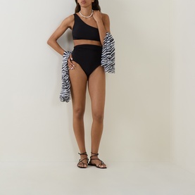 Model wearing Max Mara black one-shoulder bikini top with high-waist bikini bottoms, styled with zebra-print cover-up and strappy sandals