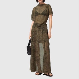 Model wearing All Saints Sali Printed Flared Skirt in Sirius Gold, maxi length with side tie detail, styled with matching top and black sandals.