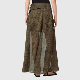 Model wearing All Saints Sali Printed Flared Skirt in Sirius Gold, maxi length with sheer seamed panels and side tie detail, back view.