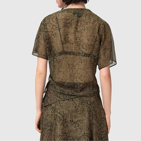 Model wearing All Saints Sali Printed Transparent Top in Sirius Gold, back view, sheer floral print with fixed pleated side seam detail.