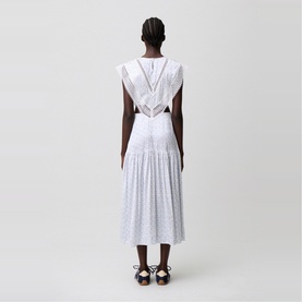 Model wearing Claude Pierlot Womens French Dress in light print, shown from behind with open back detail and pleated midi skirt.