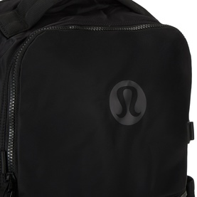Lululemon New Crew Backpack 22L in Black/Graphite Grey, close-up showing tonal logo badge and zip pockets