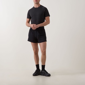 Model wearing Lululemon black performance shorts with matching black T-shirt, socks and trainers