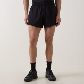 Model wearing Lululemon black performance shorts, styled with black socks and grey trainers