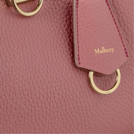 Mulberry Iris Small Top Handle Bag in Pink Scrumpy leather, close-up showing gold-tone ring hardware and branded luggage tag detail.
