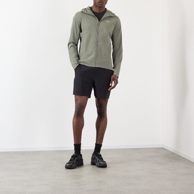 Model wearing Arcteryx Atom SL Hoodie Jacket in Forage, styled with black shorts and black trainers, full-length view