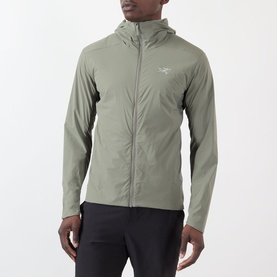 Model wearing Arcteryx Atom SL Hoodie Jacket in Forage, a lightweight green zip-up hoodie with StormHood&trade;, styled with black trousers.