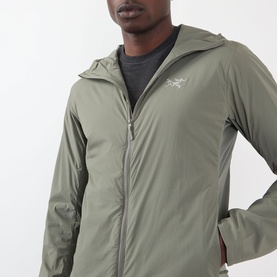 Model wearing Arcteryx Atom SL Hoodie Jacket in Forage, showing zip fastening, StormHood and embroidered logo, styled over grey top