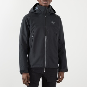 Model wearing black hooded Arc'teryx jacket with zip pockets and logo embroidery, styled with dark trousers