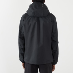 Model wearing black hooded jacket, back view, with black trousers. Structured hood, clean seam detailing, relaxed fit.