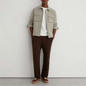 Model wearing Reiss beige overshirt with chest pockets, styled with white tee, brown trousers and tan shoes