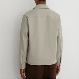 Model wearing Reiss beige shirt jacket, back view, styled with brown trousers