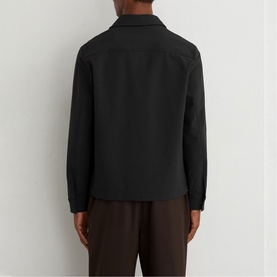 Model wearing Reiss black jacket, back view, styled with dark brown trousers