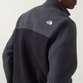 Model wearing North Face Yumiori Half-Zip Sweatshirt in Black/Grey fleece, showing embroidered logo and colour-block panelling detail.
