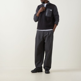 Model wearing North Face Yumiori Half-Zip Sweatshirt in Black/Grey fleece with zipped chest pocket, styled with dark trousers and black trainers.