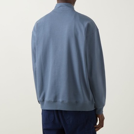 Model wearing The North Face Essential Light Half-Zip Sweatshirt in Granite Grey, shown from back, with navy trousers.