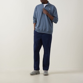 Model wearing North Face Essential Light Half-Zip Sweatshirt in Granite Grey with navy trousers and grey trainers.