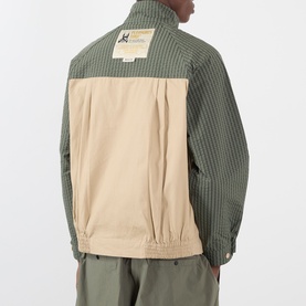 Model wearing Pleasures beige casual jacket, back view, colour-block design with olive green corduroy upper and logo patch detail