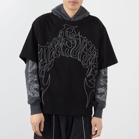 Model wearing Pleasures black cotton hoodie with abstract outline graphic, styled with grey long-sleeve top and wide-leg trousers.
