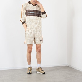 Model wearing Pleasures ecru tie-dye shorts with matching sweatshirt, white socks and beige trainers