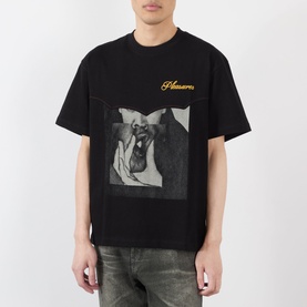 Model wearing Pleasures Ritual Graphic Print Logo T-Shirt in black with chest logo lettering and front graphic print, styled with grey distressed