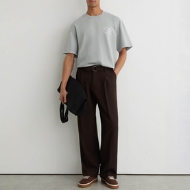 Model wearing Reiss powder blue oversized crew neck T-shirt with small chest logo, styled with dark brown trousers and a black tote bag.