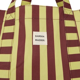 Damson Madder Green Stripe cotton tote bag, close-up showing bold green and burgundy stripes with branded label patch
