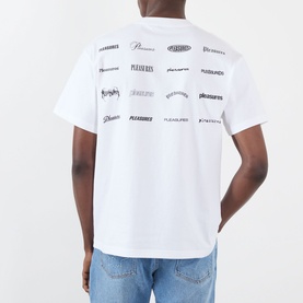Model wearing Pleasures white cotton T-shirt, back view showing allover logo print in black, styled with light blue jeans.