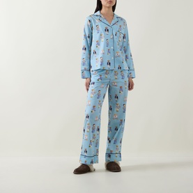 Model wearing Polo nightwear set in All Over Bear print, light blue 100% cotton long-sleeve shirt and trousers with dark piping trim.