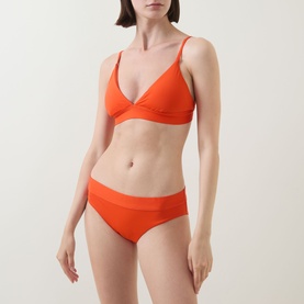 Model wearing Lauren Bikini Brief in Sunburst Orange, styled with matching triangle bikini top, smooth fabric with mesh waistband detail.