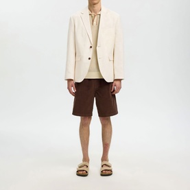 Model wearing Selected Egret blazer, styled with cream knit, brown shorts and tan sandals