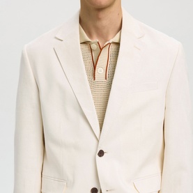Model wearing Selected Egret blazer with brown buttons, styled with a cream knit polo shirt with contrast trim detail.