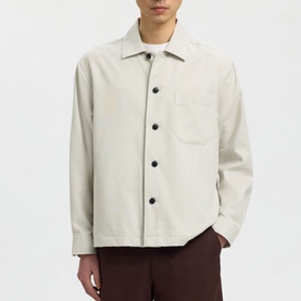 Model wearing Selected Casual Shirt in White Pepper, button-front with spread collar and chest pocket, styled with burgundy trousers