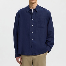 Model wearing Selected Casual Shirt in Ocean Cavern, long-sleeved navy linen-look fabric with chest pocket and white buttons, styled with beige