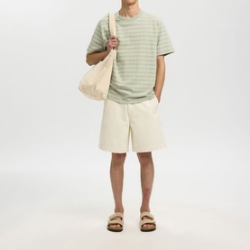 Model wearing Selected Aqua Gray striped crew neck T-shirt with cream shorts, tan sandals, and a natural tote bag.