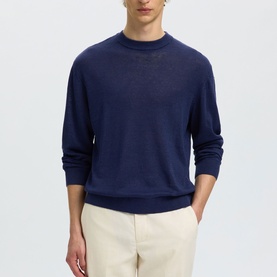Model wearing Selected Ocean Cavern crew neck knit jumper, styled with cream trousers