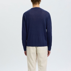 Model wearing Selected crew neck knit in Ocean Cavern, shown from rear, styled with cream trousers
