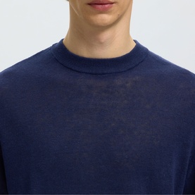 Model wearing Selected crew neck knit in Ocean Cavern, close-up showing ribbed neckline detail