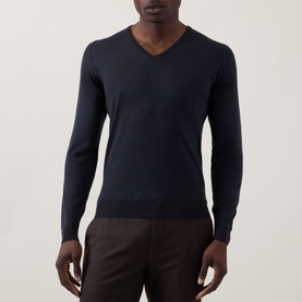Model wearing John Smedley Blenheim Extra Fine Knit Sweater in Hepburn smoke, V-neck, long sleeves, ribbed trims, styled with brown trousers