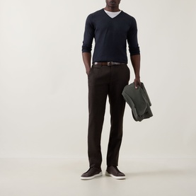Model wearing John Smedley Blenheim Extra Fine Knit Sweater in Hepburn smoke, V-neck, styled with dark trousers and white tee.