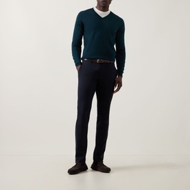Model wearing John Smedley Blenheim Extra Fine Knit Sweater in Richardson green with navy trousers and brown belt.