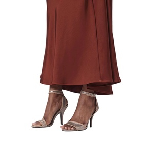Model wearing strappy stiletto heeled sandals in taupe with ankle strap and stud detail, styled with a rust-red wide-leg trouser