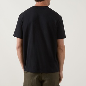 Model wearing Calvin Klein Jeans Monogram Logo T-Shirt in black, rear view, short sleeves, styled with olive trousers.