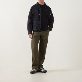 Model wearing Calvin Klein Jeans black Monogram Logo T-Shirt, styled with dark denim jacket, olive cargo trousers and trail trainers.